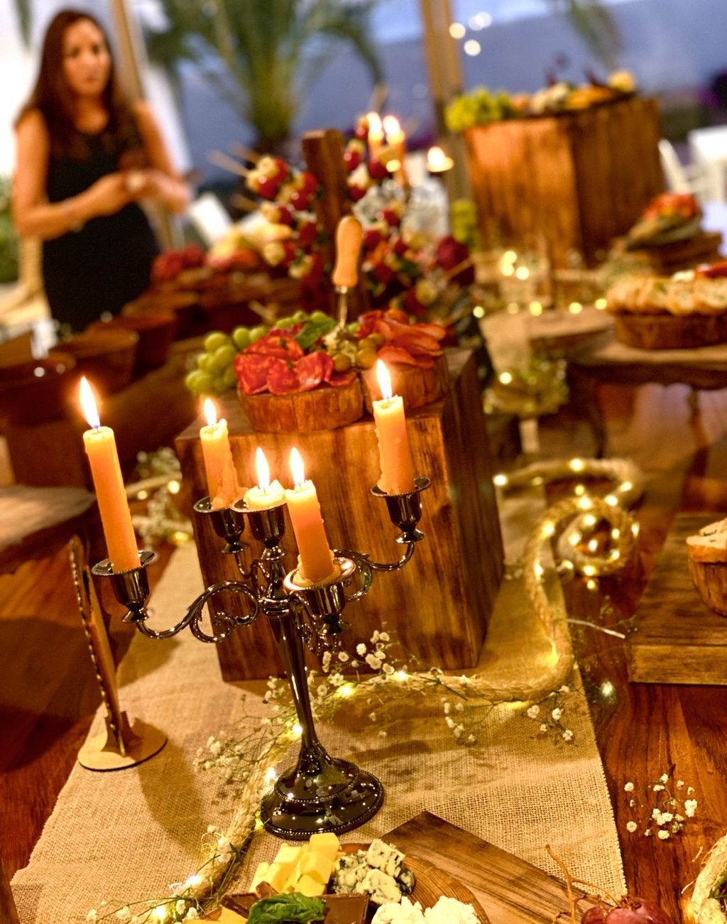 A grazing table lit by tall candles and fairy lights at a private villa celebration