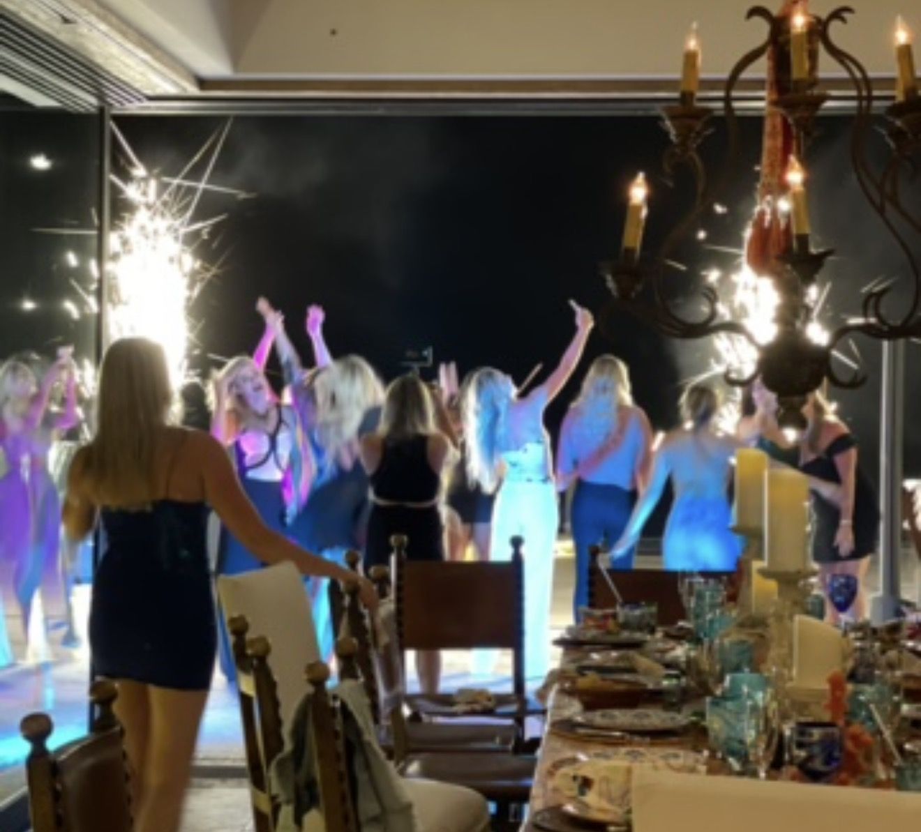 Guests raising sparklers around a long candlelit dinner table inside a Los Cabos villa