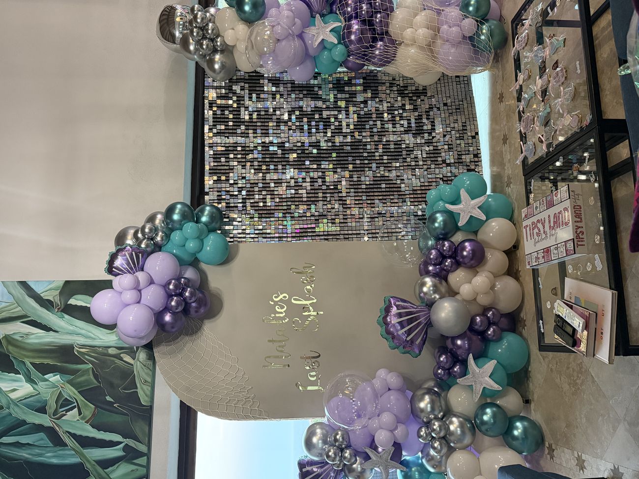 A villa entrance styled with a balloon garland and a personalised bachelorette sign