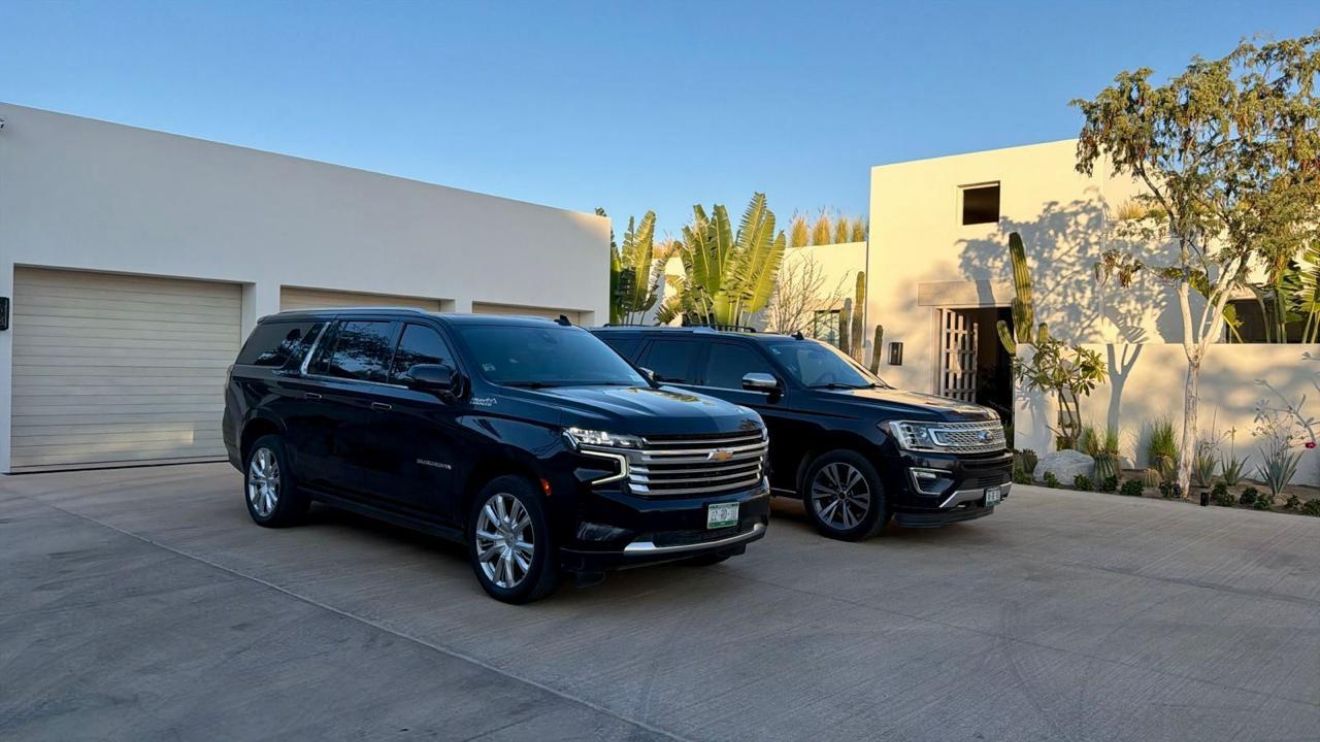 Two black SUVs waiting outside a Los Cabos villa for airport and nightlife transfers
