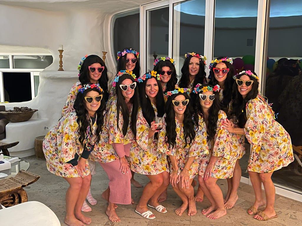 A bachelorette party in matching floral robes and flower crowns on the terrace of their Los Cabos villa